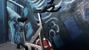 Ein Heimtrainer in einem Raum mit einer großen Wandmalerei.