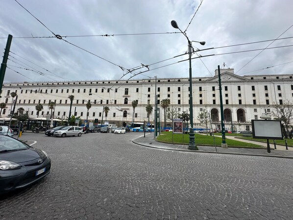 A historic building with a classical facade, a cobblestone street, and a tram line.