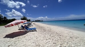 A beach with sun loungers and umbrellas, a clear blue sky, and calm sea. - 3 Bedrooms in paradise w/fruit trees 3 mins-Oistins! (Oistins)