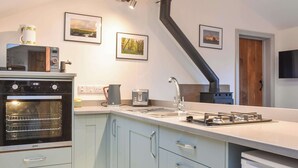 A modern kitchen with a built-in oven, a coffee maker, and a gas stove.