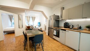 Una cocina moderna con comedor, horno empotrado y cafetera.