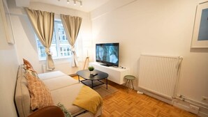 Una sala de estar moderna con un sofá, una mesa de centro, un televisor y un radiador.