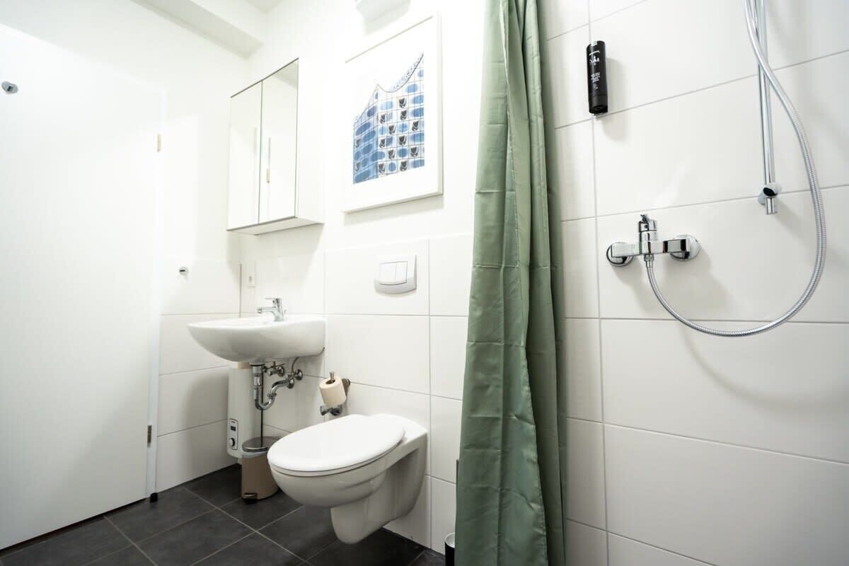 Une salle de bain moderne équipée de toilettes, d’un lavabo et d’une douche.
