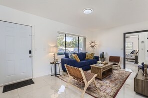 A modern living room with a sofa, coffee table, and a patterned rug.