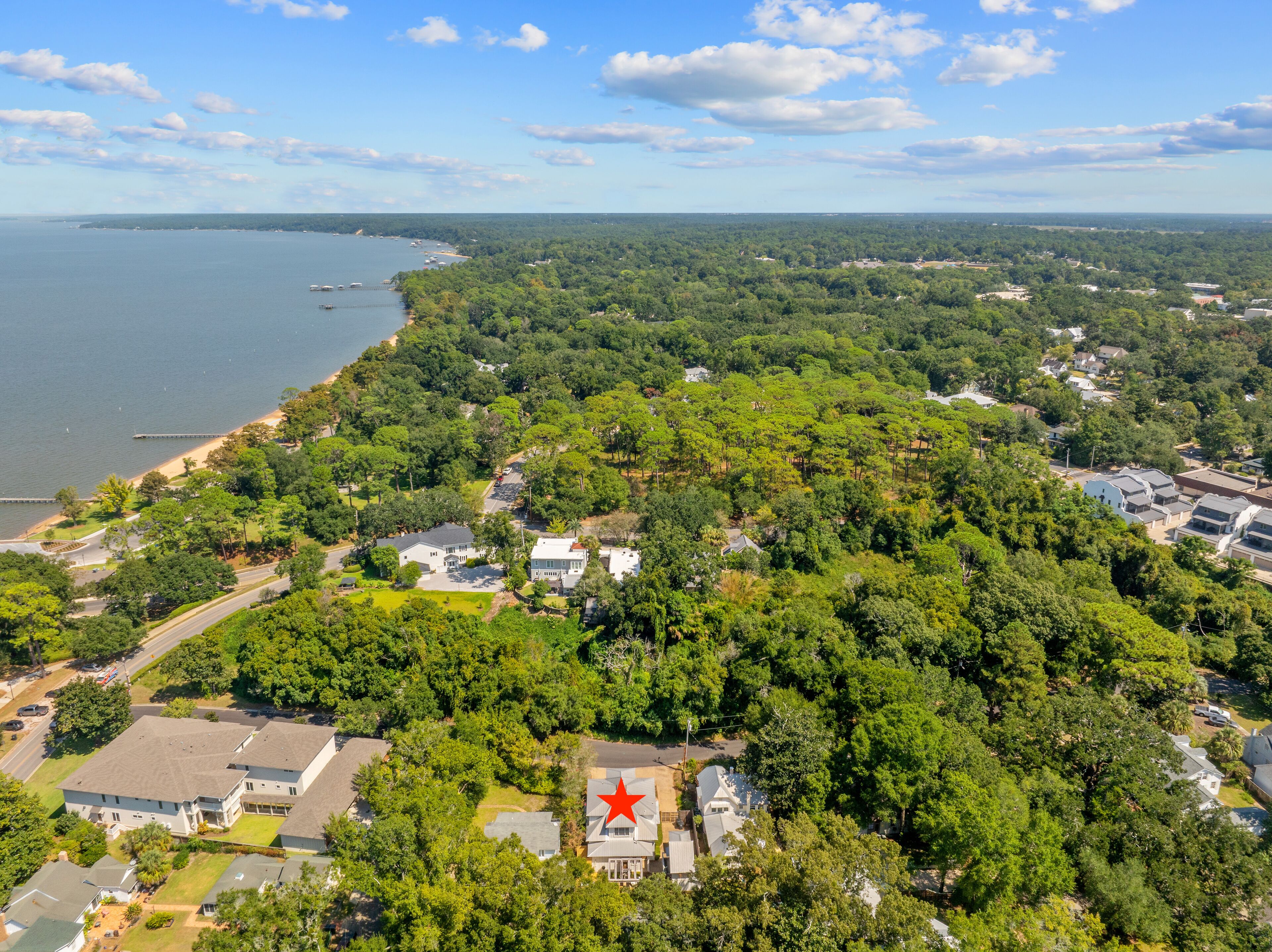 Luchtbeeld van een woongebied met huizen, een strand en een groot wateroppervlak.
