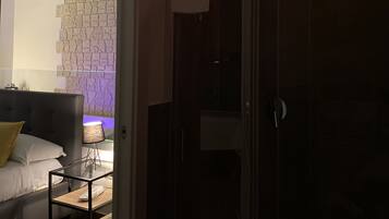 A modern bathroom with a glass shower enclosure, a towel rack, and a visible showerhead.