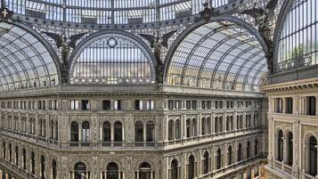 A grand, ornate building with a glass roof and intricate ironwork.
