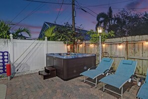 Jacuzzi con sillones de descanso en un patio trasero.