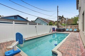 A swimming pool with a white fence, a hot tub, and lounge chairs. - Incredible 7BR | Game Room Heated Pool and Jacuzzi (Deerfield Beach)