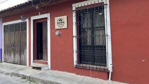 A red building with a sign reading "Casa Cerrito" and a metal gate. - Casa Cheleb (San Cristóbal de las Casas)