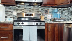 A kitchen with stainless steel appliances, wooden cabinets, and a tiled backsplash. - Modern 3BR 2BA• 5 Min to EWR • 30 Min to NYC  (Elizabeth)
