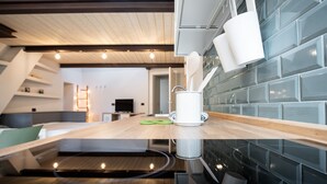 Una cocina moderna con encimera de madera, electrodomésticos blancos y salpicadero de azulejos azules.