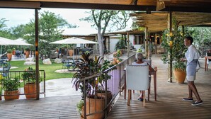 Un espace extérieur aménagé en terrasse, avec un sol en bois, des plantes en pot et des sièges d’extérieur.