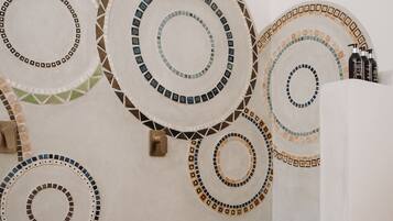A room with circular wall decorations, a shower area, and a towel rack.