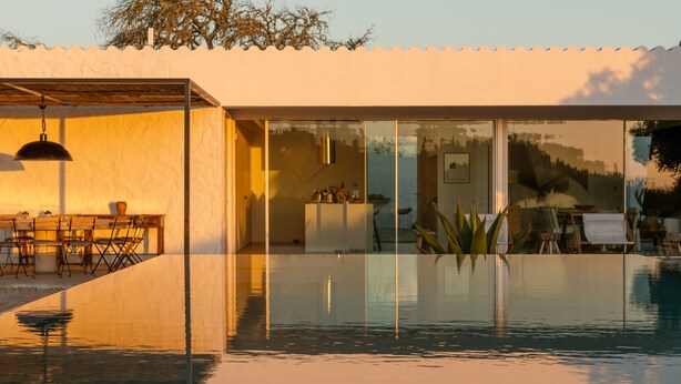 Une maison moderne dotée d’une piscine à ciel ouvert, de mobilier d’extérieur et d’un espace repas.
