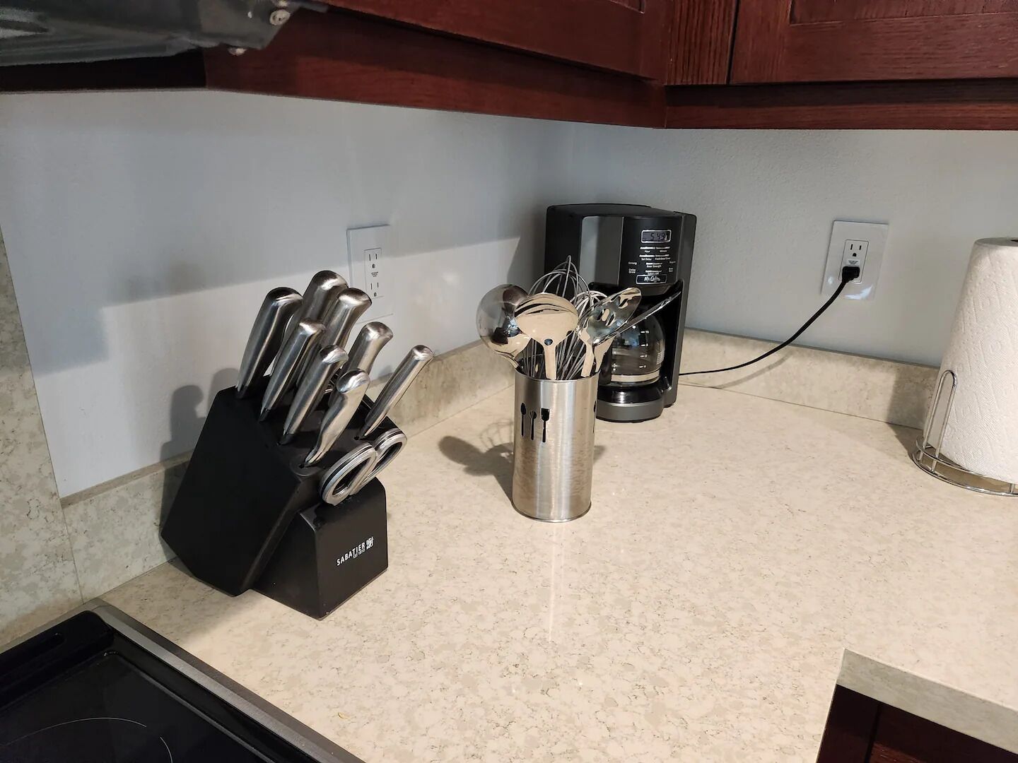 Un plan de travail de cuisine avec un range-couteaux, une machine à café et un porte-essuie-tout.