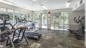 Ein Fitnessstudio mit Laufbändern, Ergometer und einem Krafttrainingsbereich.