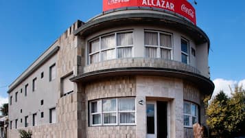 A building with a Coca-Cola sign, a curved corner design, and a visible entrance.