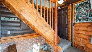 A wooden staircase with a handrail leading to a door with a decorative panel. - Experience comfort at The Bucking Moose (#02) The Loft, just 1 minute from Yellowstone! (West Yellowstone)