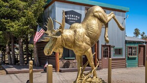 A golden moose statue in front of a building labeled "Bucking Moose Cabins." - The Gopher Queen Room at The Bucking Moose, just 1 minute from Yellowstone in West Yellowstone. (West Yellowstone)