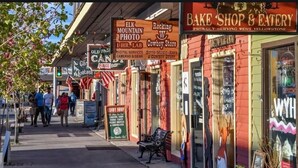 A street lined with various shops, including a bakery and a candy shop. - The Gopher Queen Room at The Bucking Moose, just 1 minute from Yellowstone in West Yellowstone. (West Yellowstone)