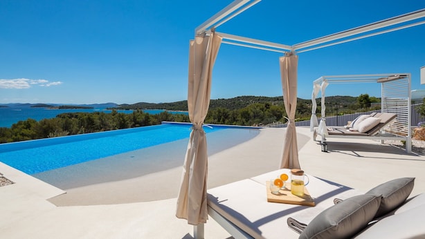 A private pool with a clear view of the sea and hills, a covered seating area with cushions, and a table with a drink and fruit. - Luxury Villa Siesta with Pool (Jezera)
