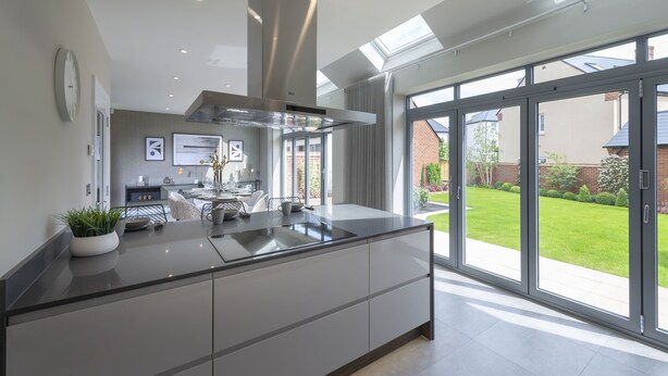 Una cocina moderna con una isla central, ventanas amplias y vistas al exterior.