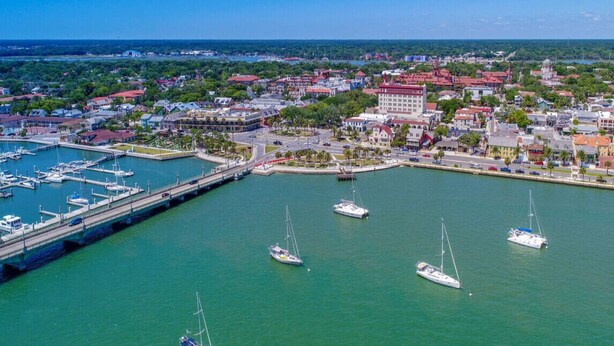 An aerial view of a coastal city with a marina, boats, and buildings. - Entire Home: Coastal 3BR Escape with Garage & Pets (St. Augustine)