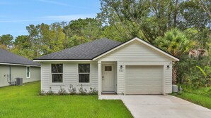 A single-story house with a garage, a front door, and a small porch. - Entire Home: Coastal 3BR Escape with Garage & Pets (St. Augustine)