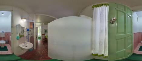 A bathroom with a toilet, sink, and green mat.