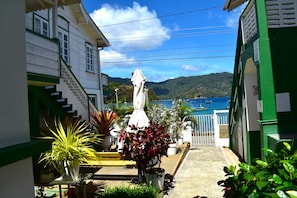 A narrow street with buildings on either side, a bench, and potted plants. - CHOLSON CHALETS LIMITED (Charlotteville)