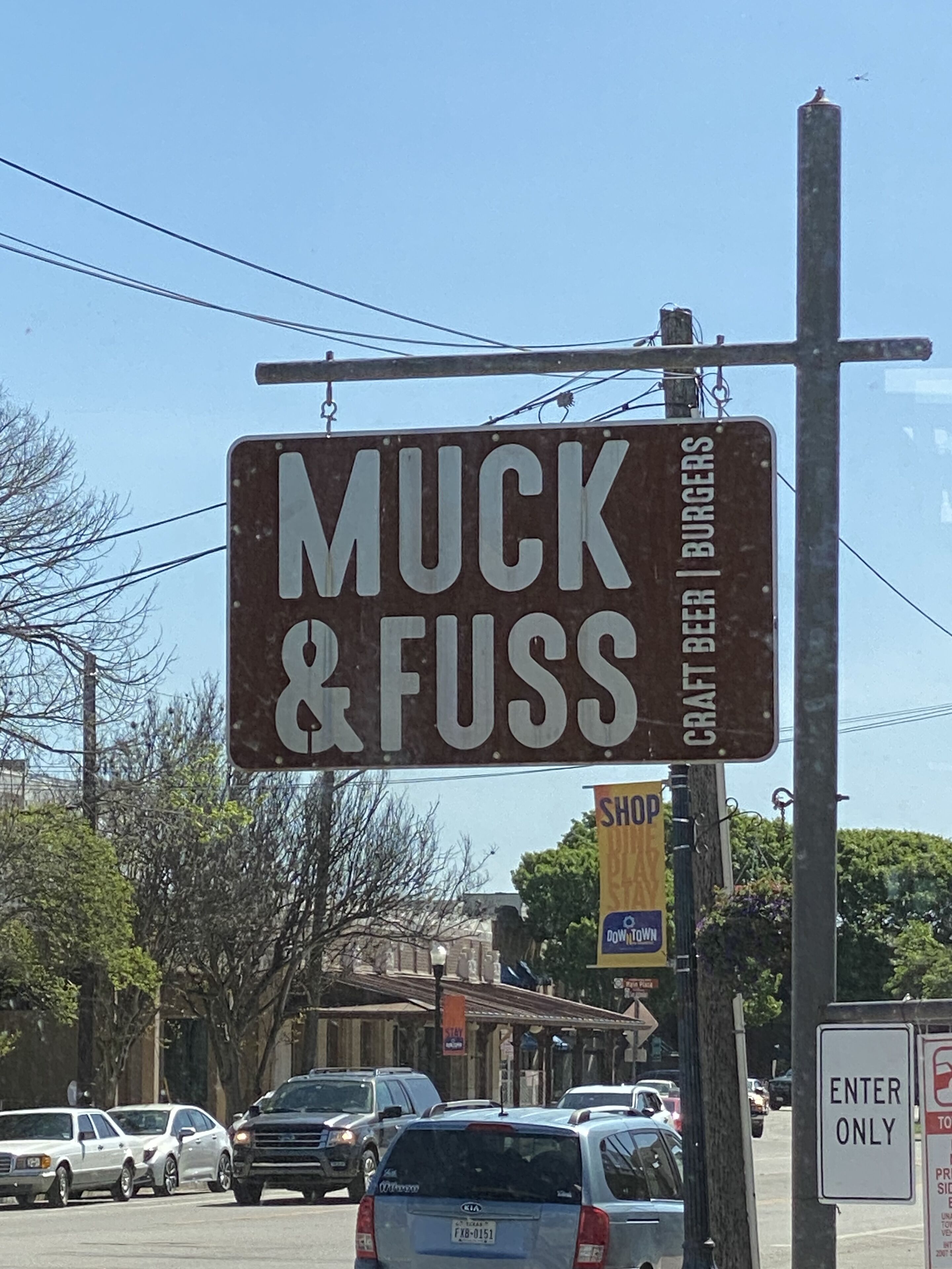 Ett gatukors som visar vägen till ”Muck & Fuss”, en bar som serverar hantverksöl och hamburgare.