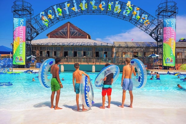 A swimming pool area with a large archway and banners.