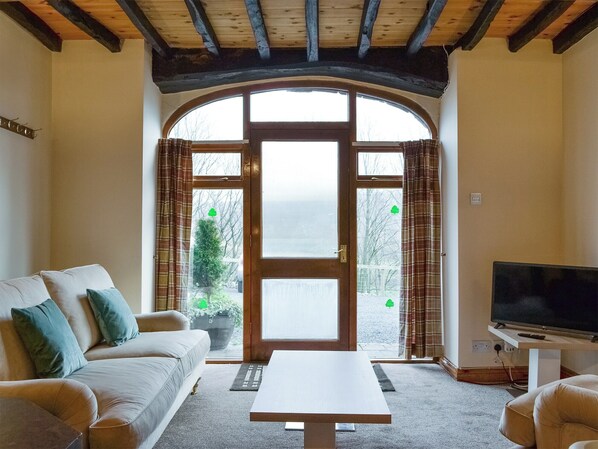 A cozy living room with a sofa, a coffee table, and a television. - Doddick Chase Cottage - UK1363 (Threlkeld, near Keswick)