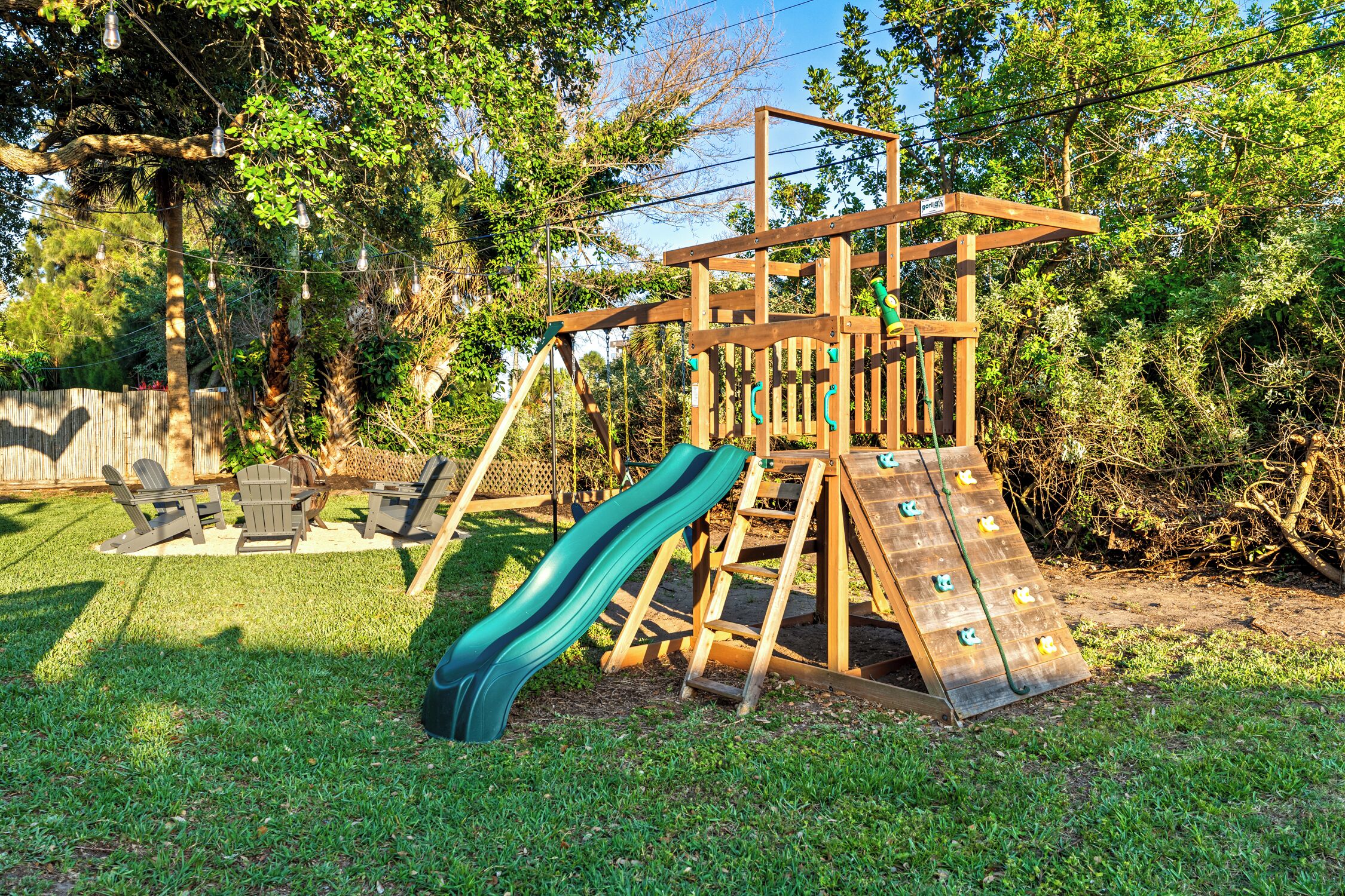 Una estructura de juego de madera con un tobogán y elementos para escalar en un patio trasero.