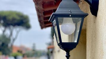 A black outdoor wall-mounted light fixture with a clear glass cover and a visible bulb.