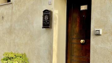 A building with a dark brown door, a mailbox, and a potted plant by the entrance.