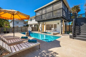 A residential property with a swimming pool, outdoor seating, and a covered patio area. - The Laguna Beach: 2 Blocks to Beach, Pool, 5 Hole Put Put, Foosball, Cornhole by Anna Maria Life (Anna Maria)
