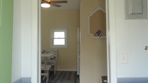 Un pasillo con un letrero que dice "Tezera Hideaway", un ventilador de techo, una ventana y una puerta con cerradura numérica.