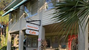 A building with a sign reading "Nature Coast Cafe" and a number "649" on the door. - Nature Coast Inn and Cottages (Inglis)