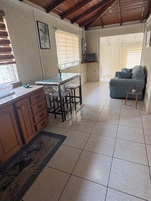 Una cocina amplia con una mesa de comedor, armarios de madera y piso de baldosas.