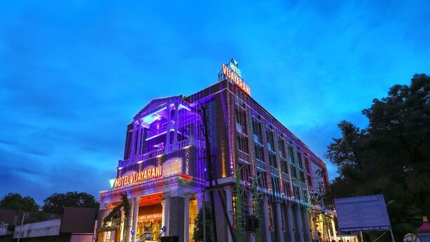 Un hotel con un letrero llamativo y fachada iluminada al anochecer.