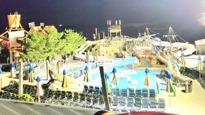 Un parque acuático con una piscina grande, toboganes y una estructura temática pirata.