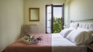 Ein Schlafzimmer mit Bett, Stuhl, Fenster und Heizkörper.