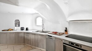 Una cocina moderna con lavavajillas integrado, cocina y ventana sobre el fregadero.