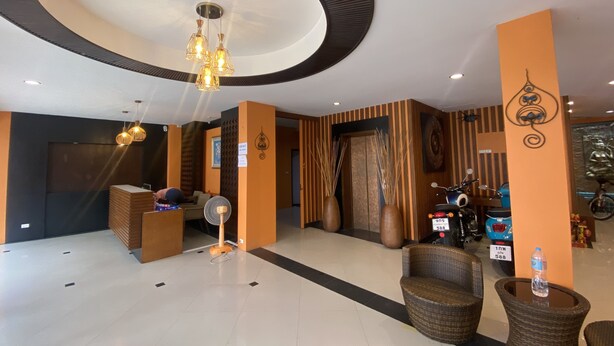 A modern lobby with a large circular ceiling design, wicker furniture, and a ceiling fan. - Cocoon Deva Hotel (Patong)