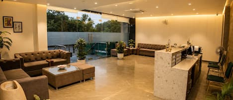 A modern living room with a sofa, coffee table, and a reception desk.