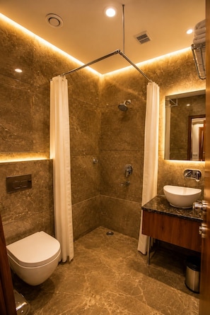 A modern bathroom with a shower, toilet, and sink.