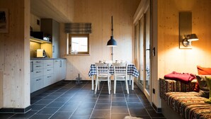 Un intérieur chaleureux comprenant une cuisine, un coin repas et un espace salon.
