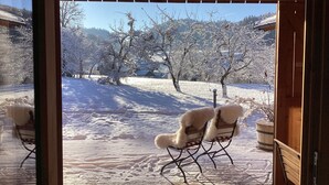 A wooden deck with two chairs facing a snowy landscape. - Chalet am Quittenbaum, whole house, 140 sqm for 2-6 persons, 2 bedrooms, 2 bathrooms, sauna (Unterwössen)